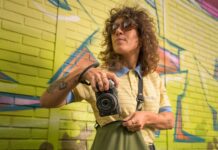 Nikon Z5IIC : le plein format à la portée des débutants Photographe tenant un Nikon Z5IIC argenté devant un mur couvert de graffitis